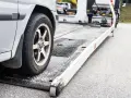 Koło samochodu na lawecie, przygotowanego do transportu. Może to być konfiskata samochodu lub jego holowanie.