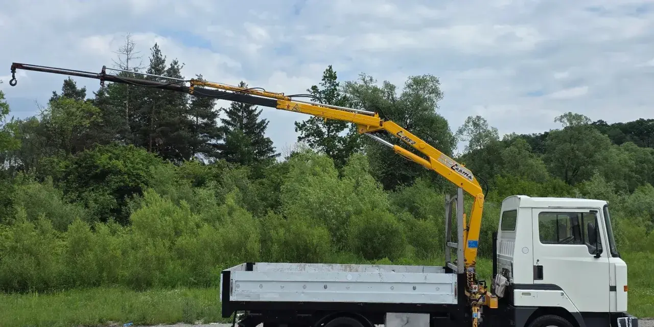 Biała ciężarówka z żółtym dźwigiem, gotowa do pracy. Ten Nissan Atleon z pewnością ułatwi transport.