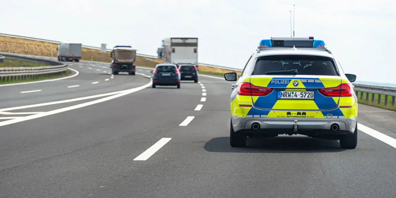 Niemiecki radiowóz na autostradzie, jadący za innymi pojazdami.