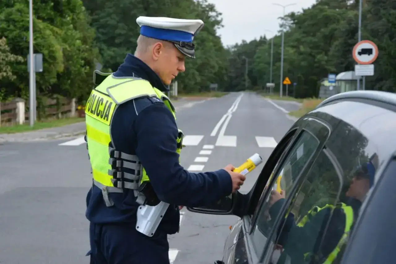 Policjant w kamizelce odblaskowej z napisem 